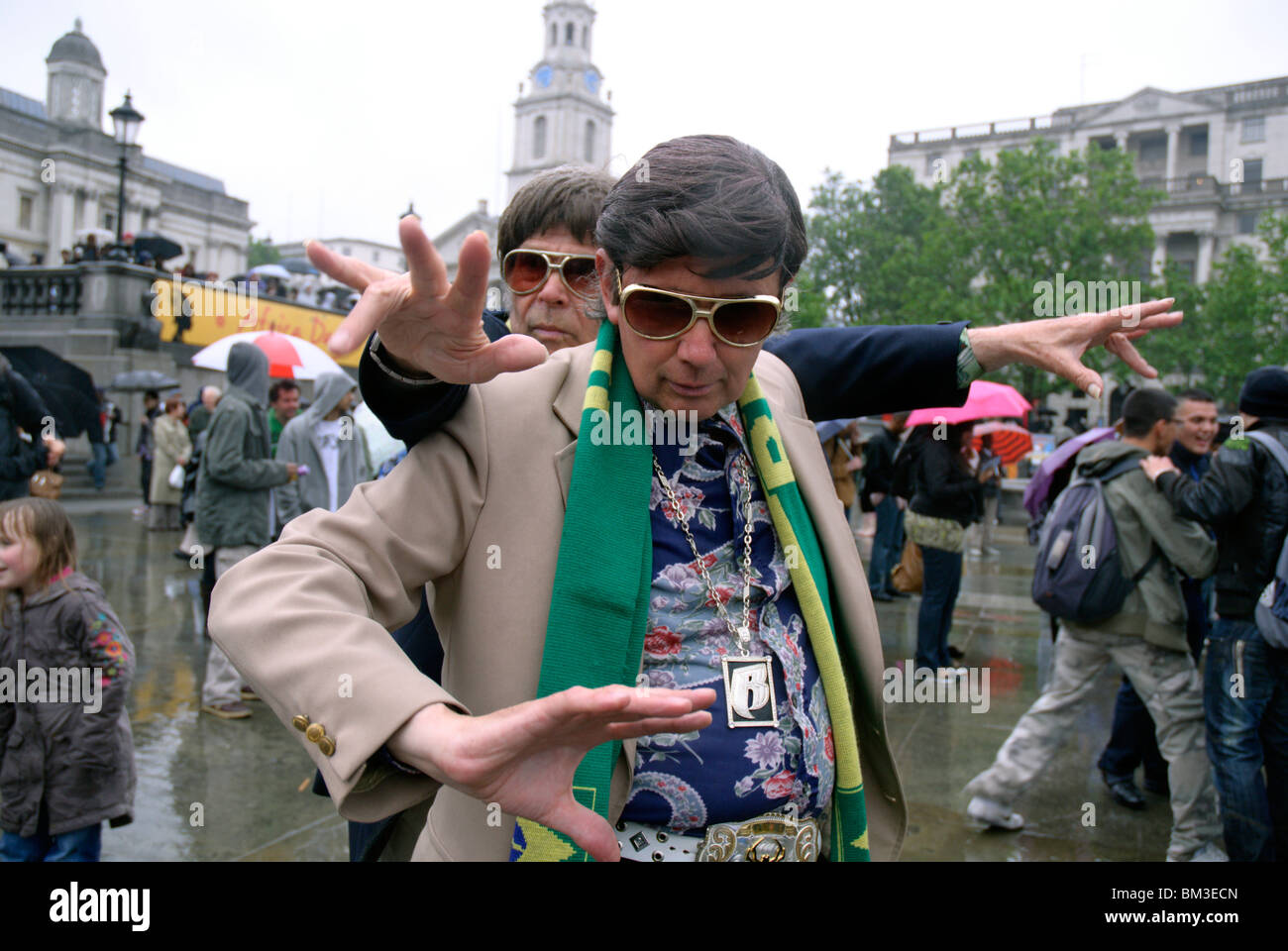 Gli uomini ballando sotto la pioggia al concerto celebrare la Giornata dell'Africa, Trafalgar square , Londra, Regno Unito Foto Stock