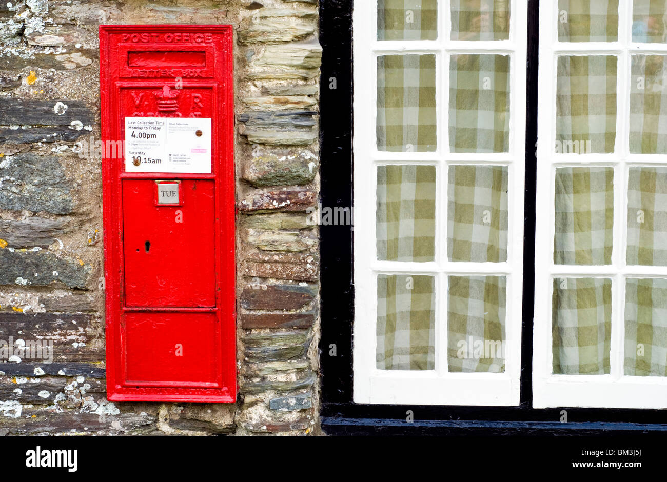 Un rosso postbox sulla parete del vecchio ufficio postale di Tintagel, Cornwall, Regno Unito Foto Stock