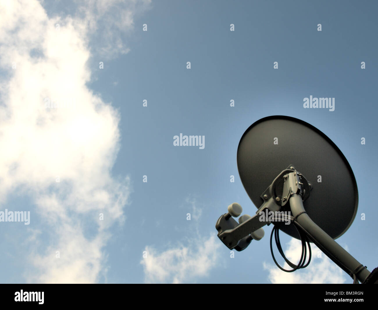 Televisione via satellite TV piatto sul tetto guardando in alto nel cielo di nuvole fili round Foto Stock