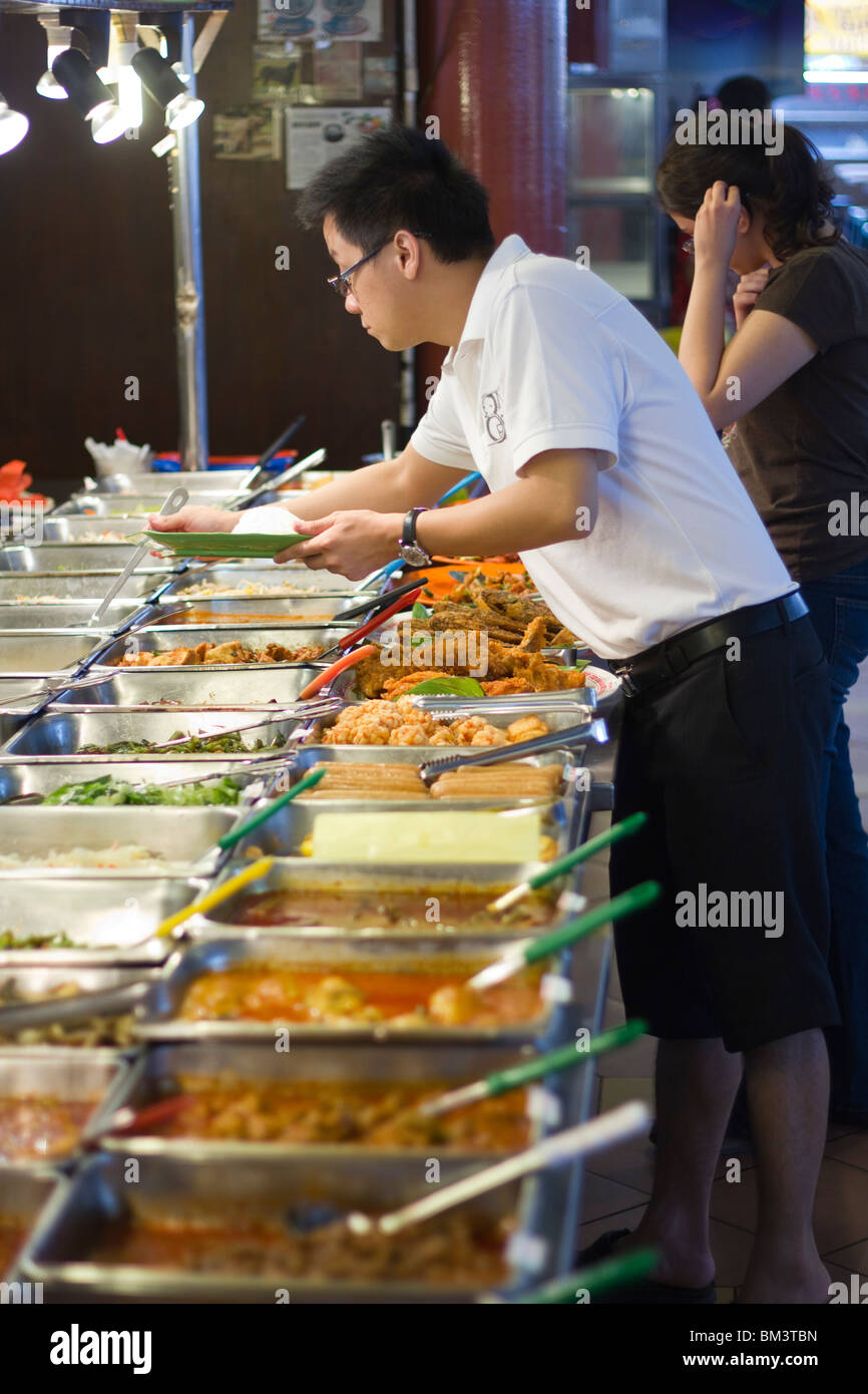 L'uomo la scelta di cibo dalla miscela di riso in stallo il Taman megah food court, Damansara, Malaysia Foto Stock