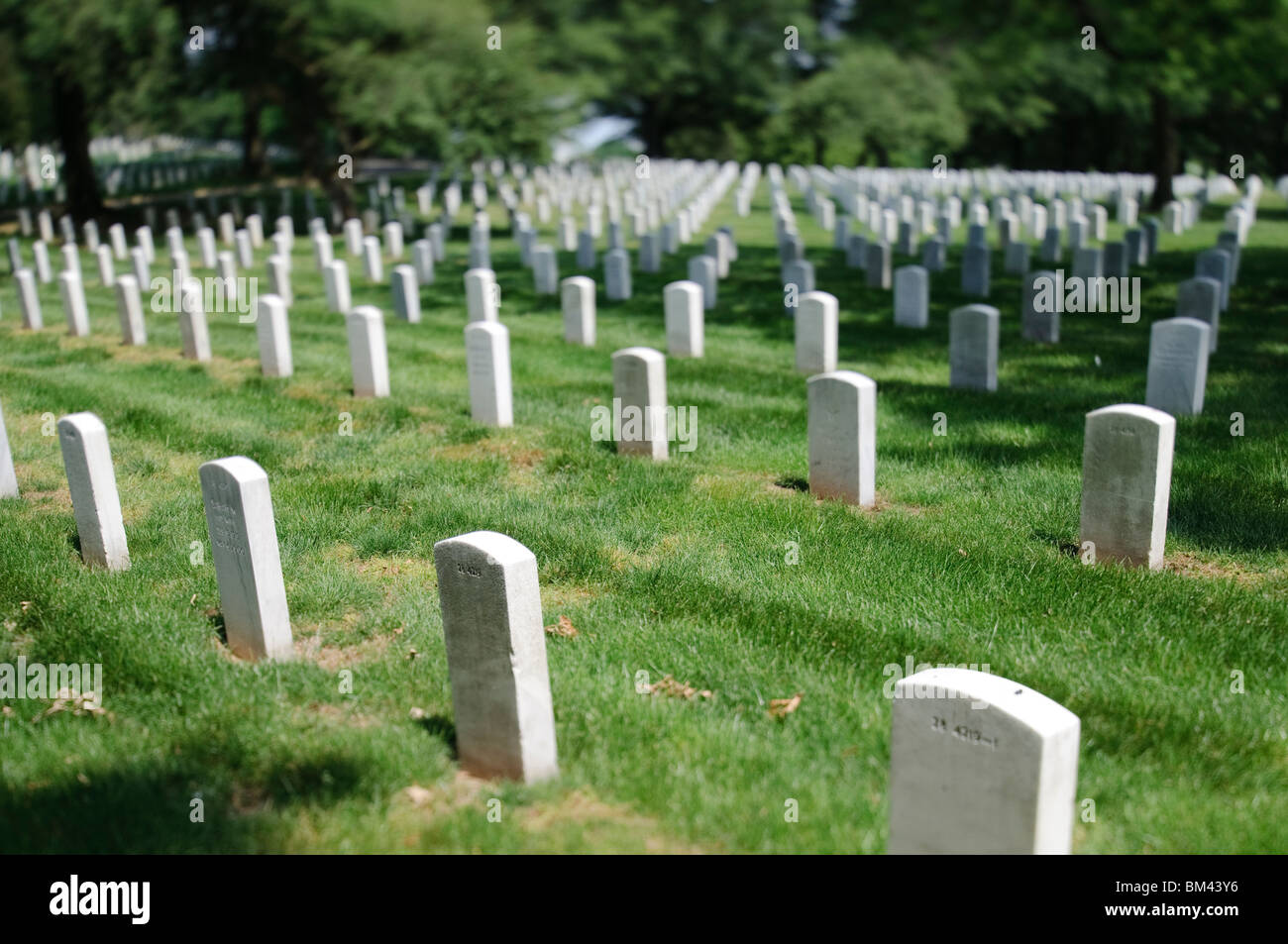 Arlington National Cemetery Headstones Arlington Virginia // ARLINGTON, Virginia - file di lapidi in marmo bianco si trovano in un preciso allineamento geometrico al cimitero nazionale di Arlington. Ogni lapide segna il luogo di riposo finale di un membro dei servizi militari degli Stati Uniti o di un membro della famiglia idoneo. Il cimitero contiene oltre 400.000 tombe su 639 acri. Foto Stock