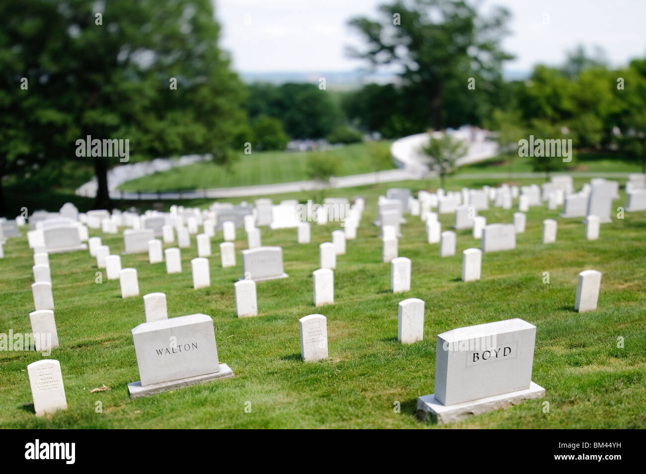 Arlington National Cemetery Headstones Arlington Virginia // ARLINGTON, Virginia, Stati Uniti - file di lapidi di marmo bianco si estendono attraverso i terreni del cimitero nazionale di Arlington, creando un paesaggio solenne e visivamente suggestivo. Queste lapidi uniformi segnano gli ultimi luoghi di riposo dei militari e delle donne americane, nonché dei civili di rilievo. Il cimitero meticolosamente mantenuto funge da potente tributo a coloro che hanno servito gli Stati Uniti, offrendo un posto per la memoria e la riflessione sui sacrifici fatti per la nazione. Foto Stock