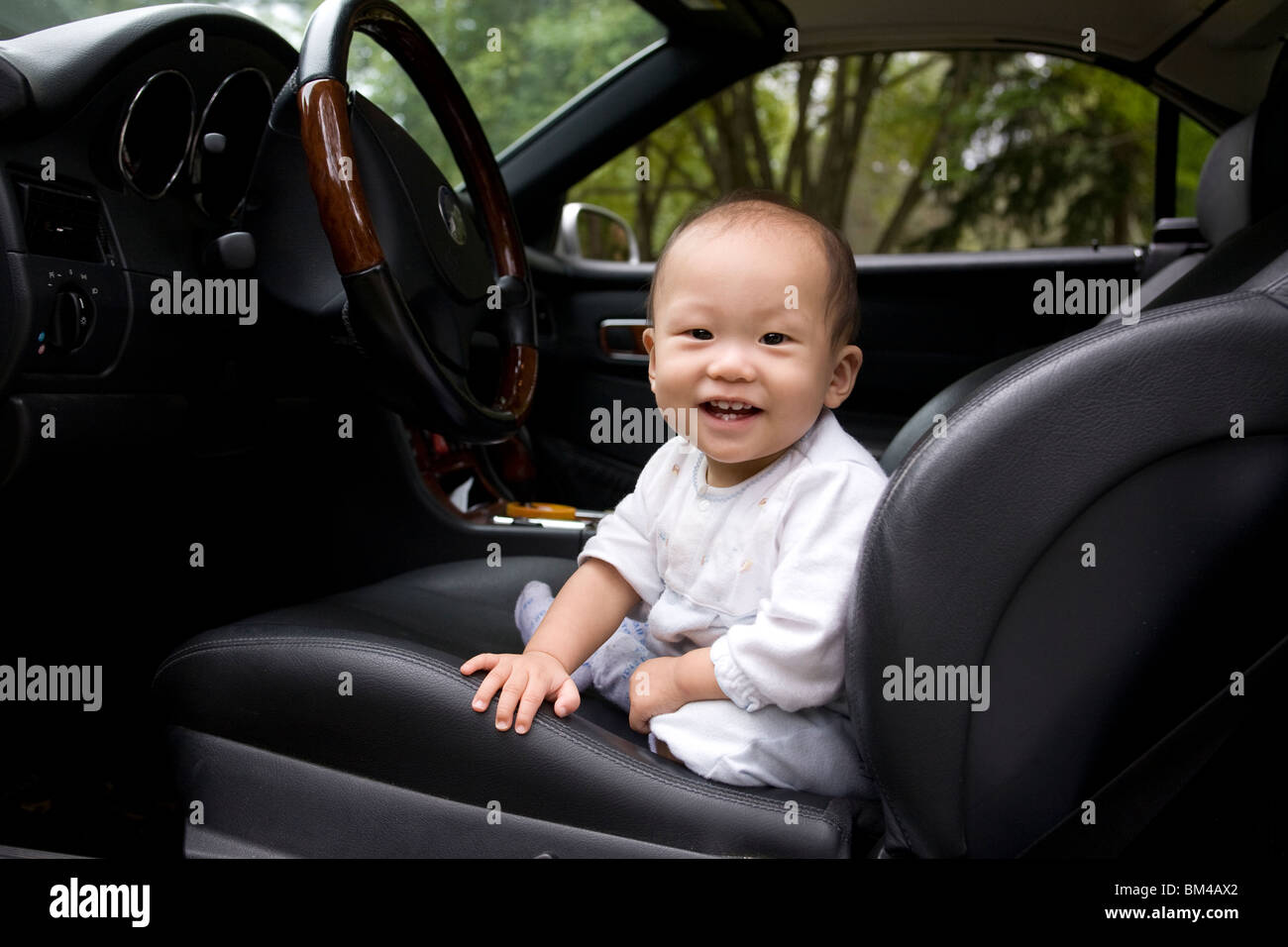 Asian bimbo seduto in auto del sedile conducente Foto Stock