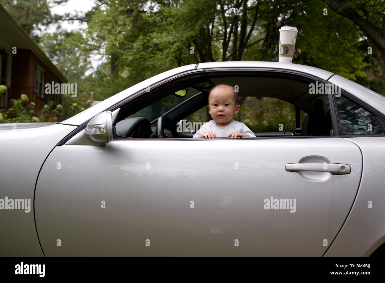 Asian baby boy guardando fuori della finestra auto Foto Stock