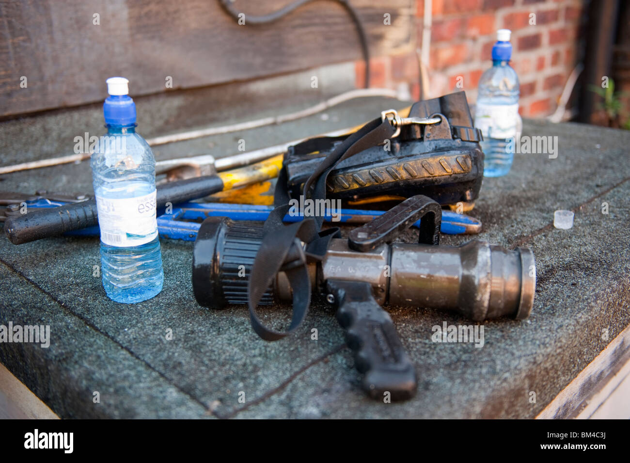 Fire hosereel ugello e bottiglie di acqua Foto Stock