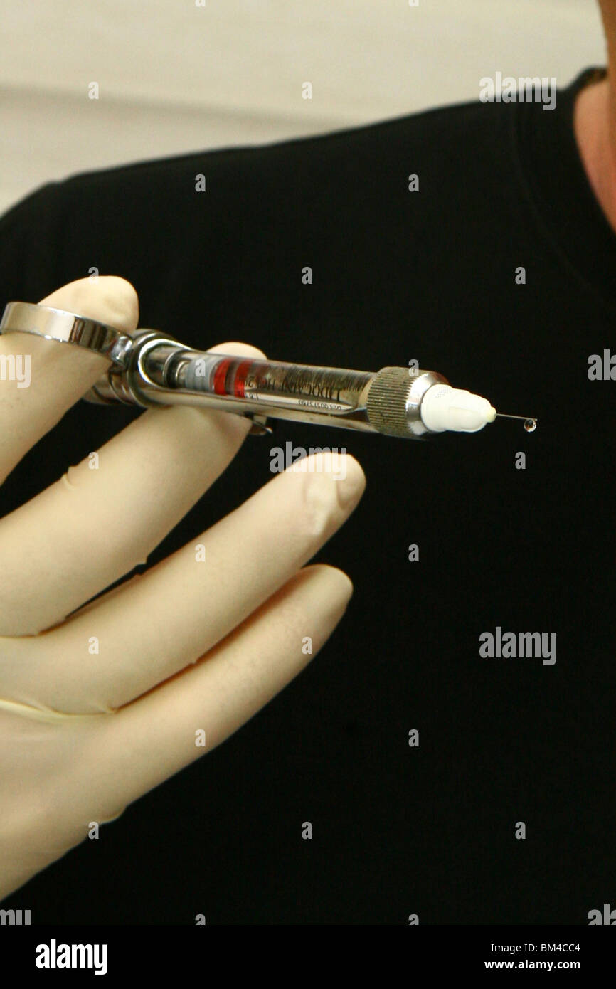 Un dottore mano trattiene una siringa con Botox tossina cosmetici. Foto Stock