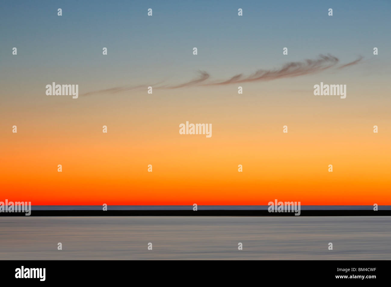 Un singolo, simili a piume derive cloud attraverso una brillante twilight sky in Ludington, Manistee County, Michigan Foto Stock