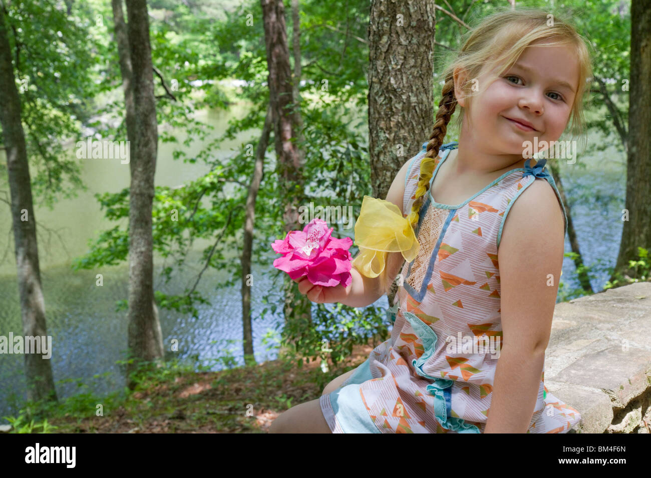 Una bambina di 5 anni con un fiore: Divertimento all'aperto, Georgia, USA. Foto Stock