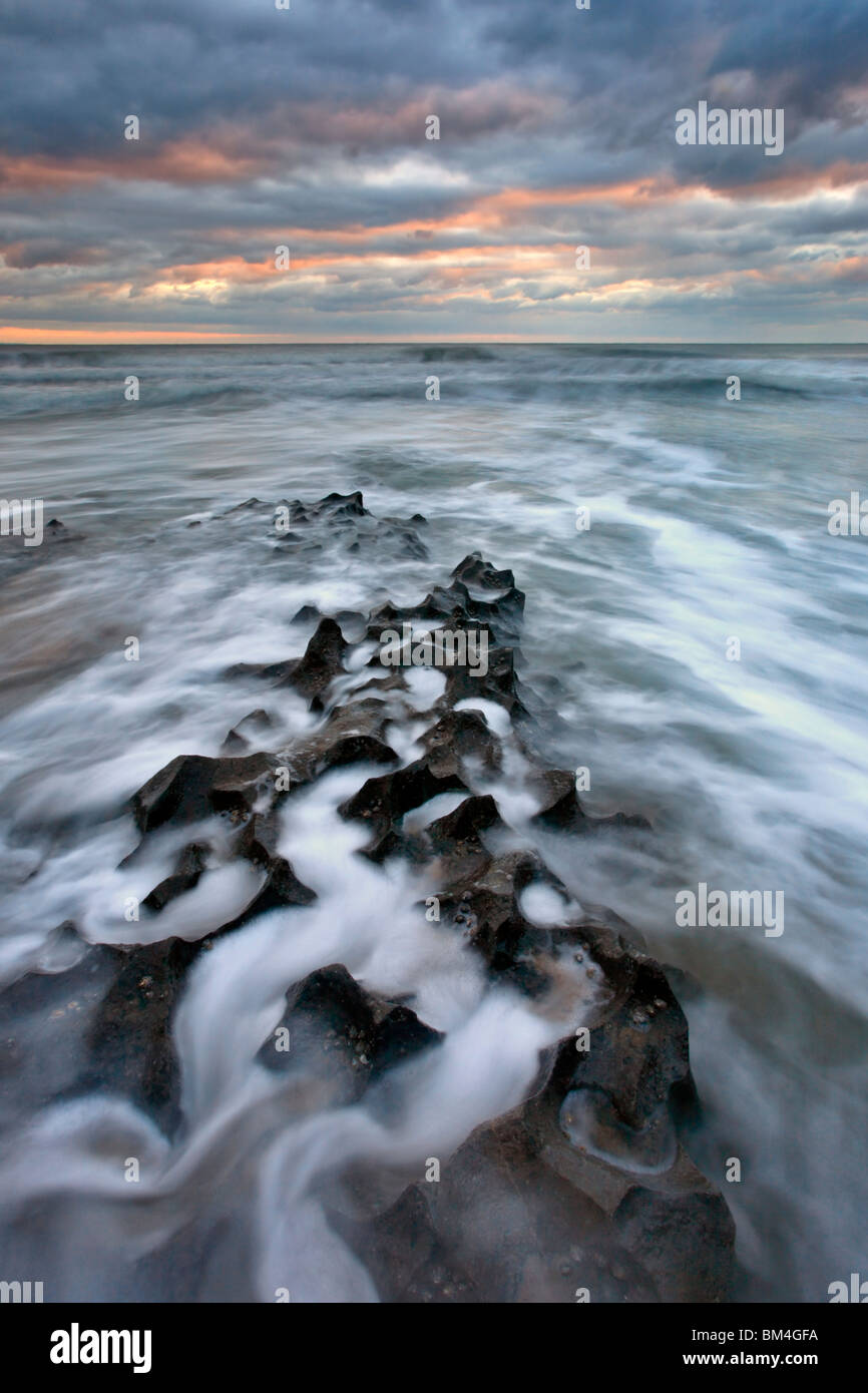 La marea lavaggi in tutta l'ultraterreno formazioni rocciose a Mewslade Bay sulla Penisola di Gower, Wales, Regno Unito Foto Stock