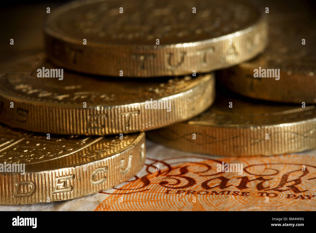 Close up di £ 1 monete che circonda la didascalia ' Banca, prometto di pagare' su £10 nota Foto Stock