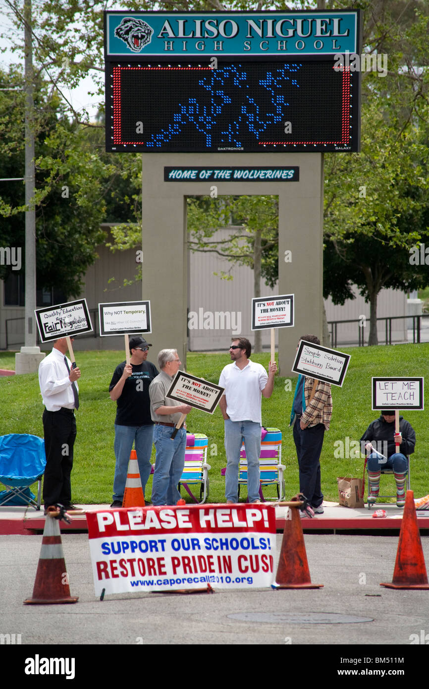 Protestando proposto tagli dei salari, che colpisce di alta scuola di picchetto insegnanti della loro scuola nel Aliso Viejo, California. Foto Stock