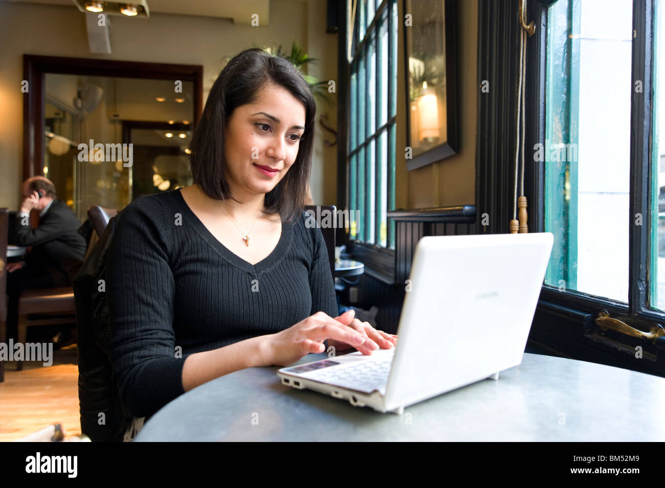 Giovane donna navigando in internet cafe, England, Regno Unito Foto Stock