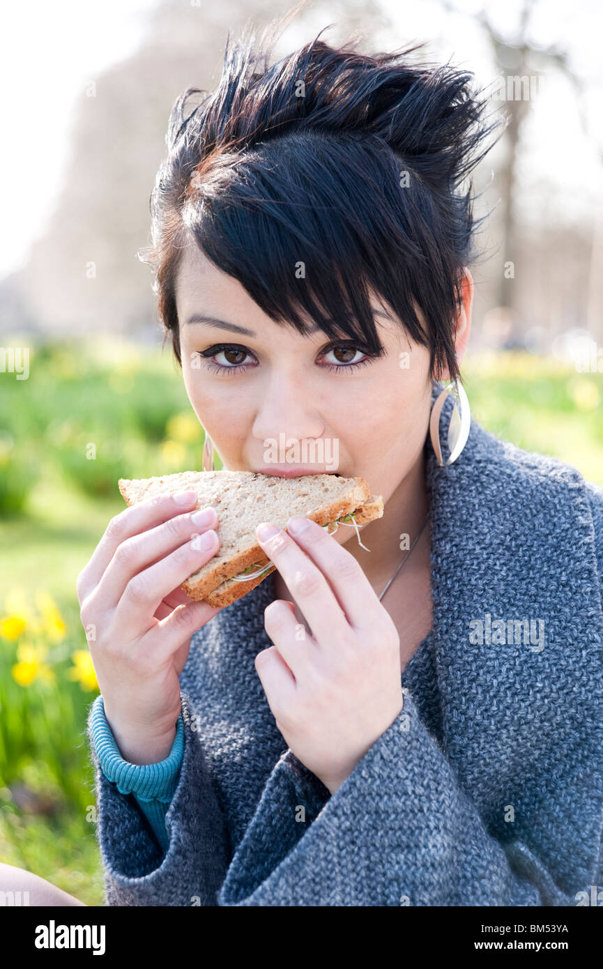 Giovane donna mangiare supermercato sandwich, England, Regno Unito Foto Stock