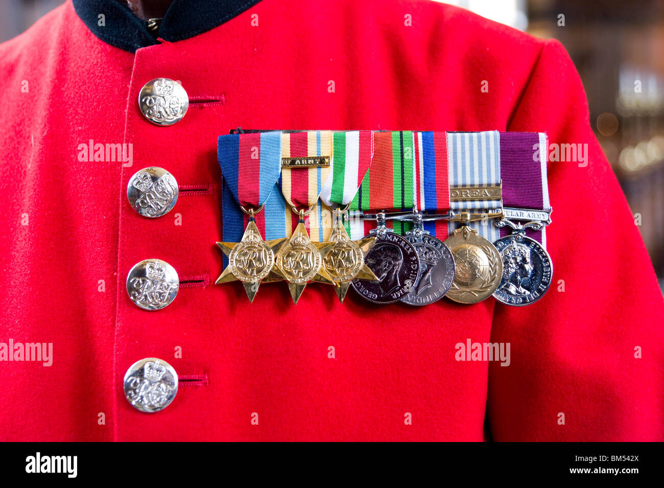 Le medaglie di guerra su scarlet cappotto di In-Pensioner John Ley presso il Royal Hospital Chelsea a Londra, in Inghilterra, Regno Unito Foto Stock