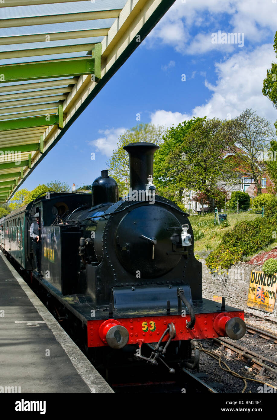 Motore a vapore locomotiva e carrozze turistiche tirando in Swanage storica stazione ferroviaria Swanage Dorset Regno Unito Foto Stock