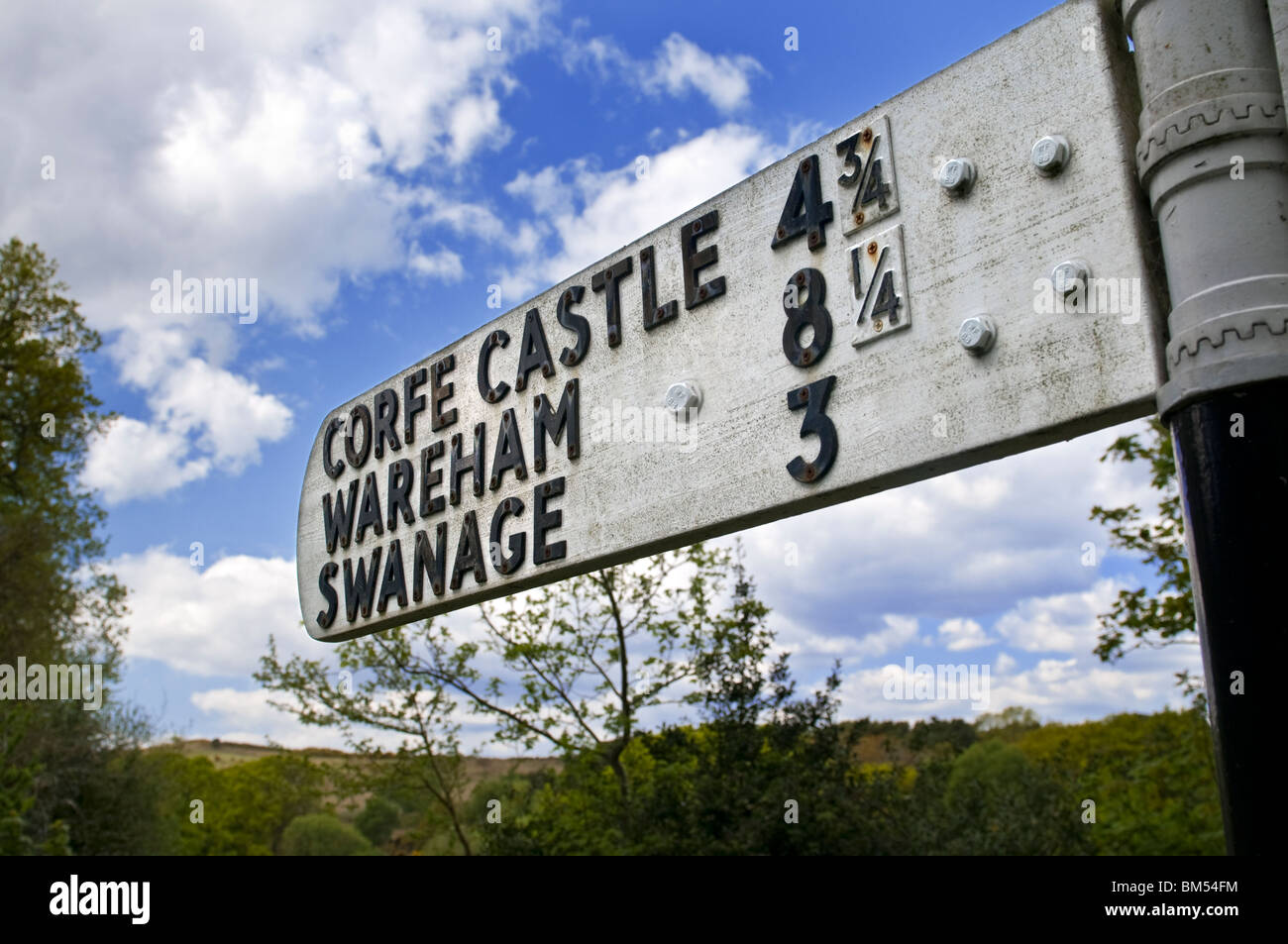 Inglese tradizionale con cartello stradale rivolta verso Corfe Castle Wareham e Swanage Dorset Regno Unito Foto Stock