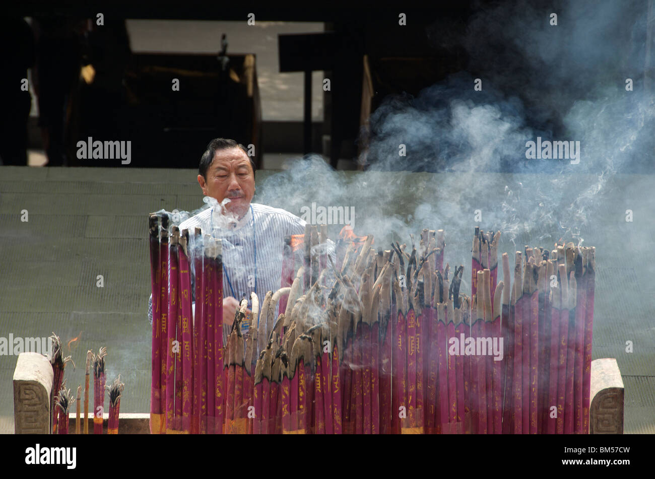 L'uomo bruciare bastoncini di incenso nel tempio Yuwang in Huguang Guild Hall nel quartiere vecchio di Chongqing Cina Foto Stock
