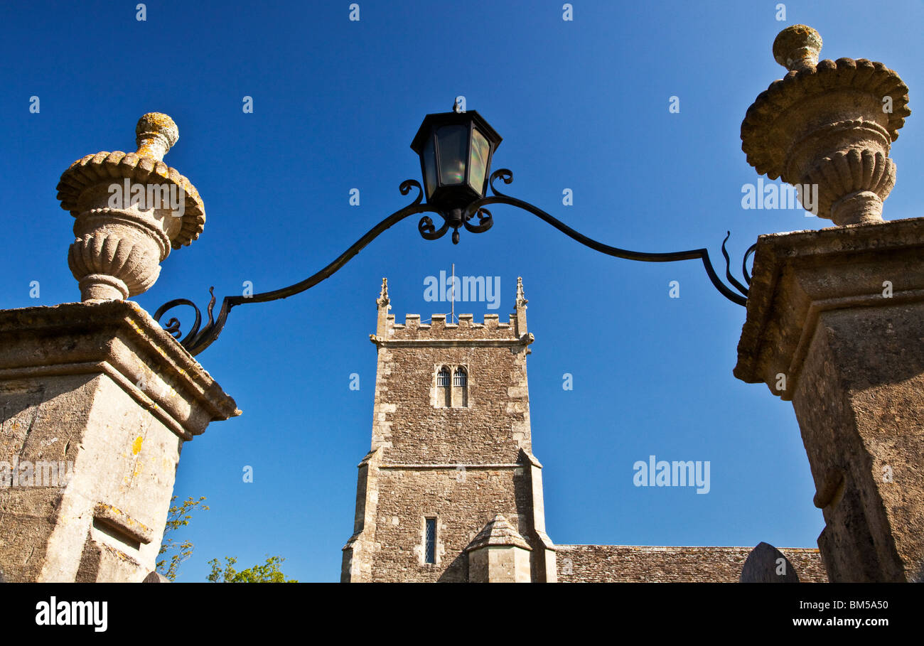 La torre del XV secolo di San Pietro e San Paolo villaggio chiesa in grande Somerford, Wiltshire, Inghilterra, Regno Unito visto attraverso il gateway. Foto Stock