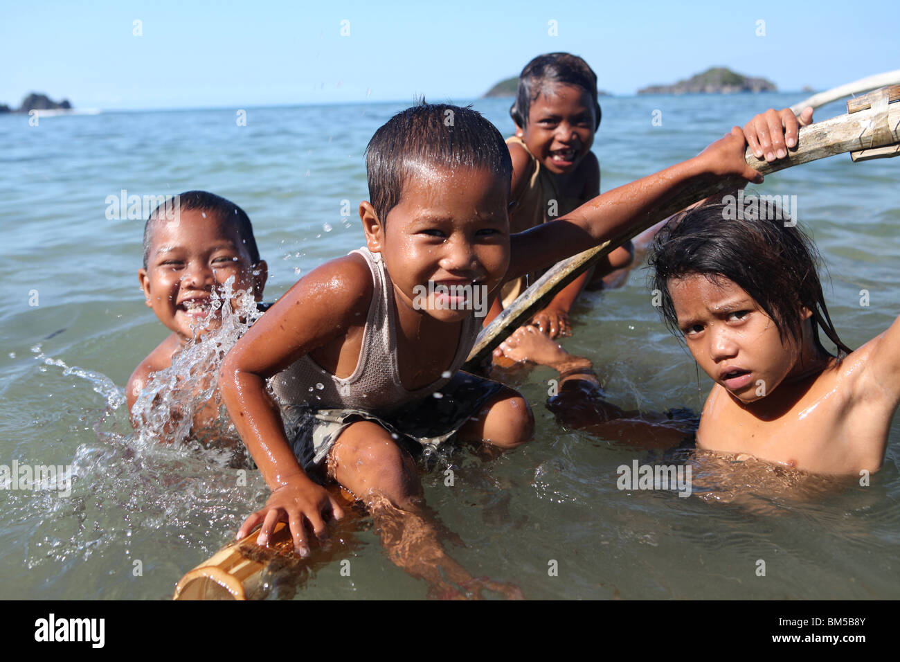 I bambini giocano su una barca in Caramoan isole nel sud est di Luzon, Filippine. Foto Stock