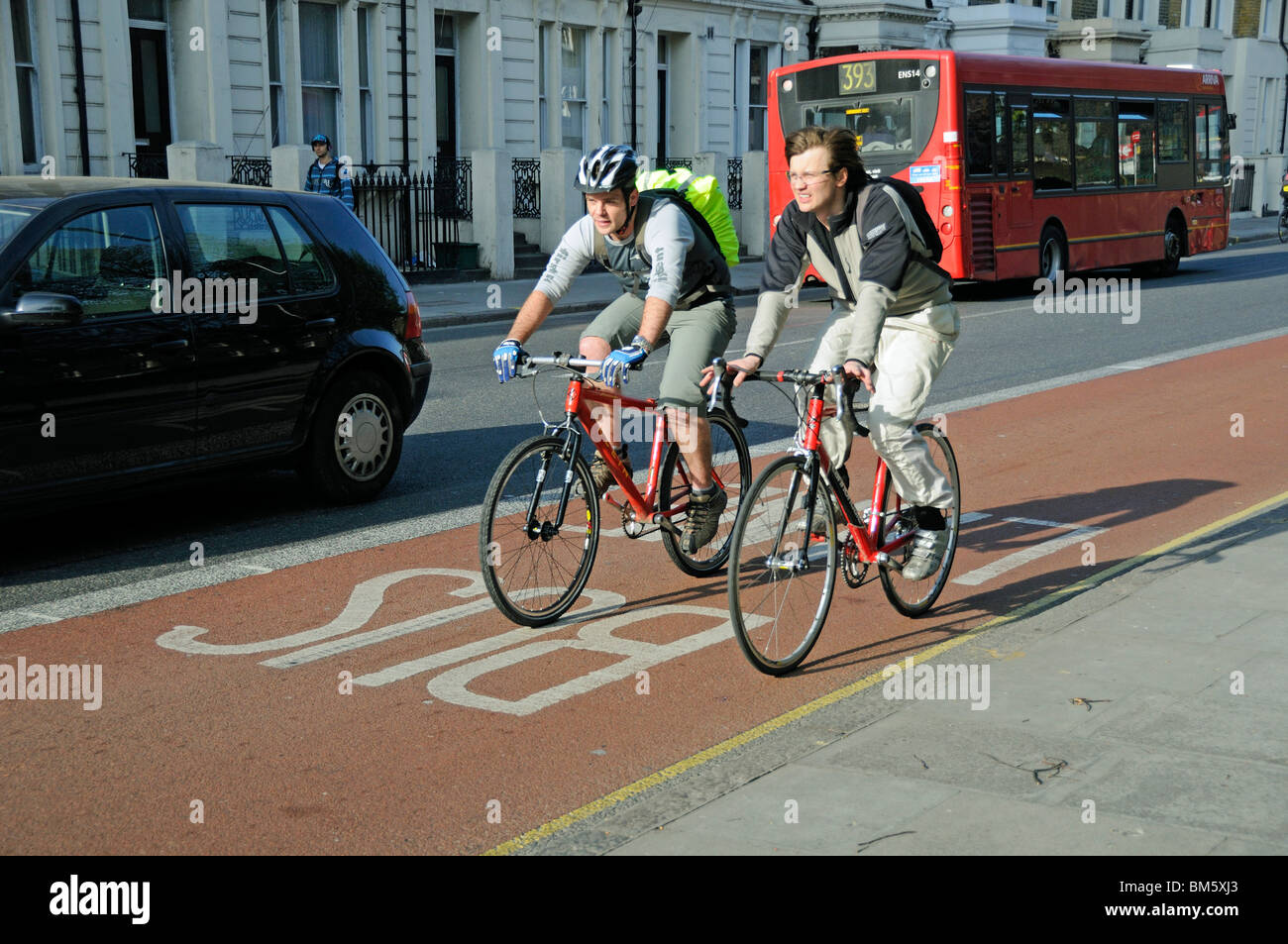 Due maschi giovani ciclisti nella corsia degli autobus Islington Londra Inghilterra REGNO UNITO Foto Stock