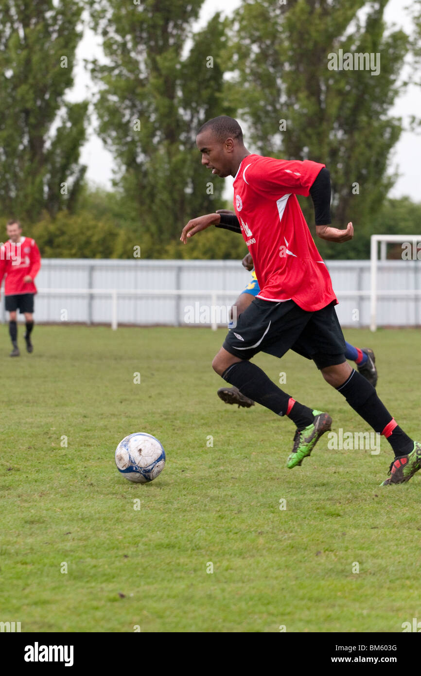 Un calciatore locale sull'attacco Foto Stock