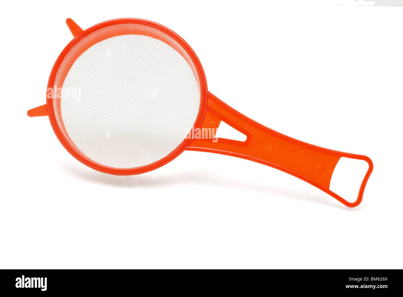 Rosso in plastica setaccio da cucina su sfondo bianco Foto Stock