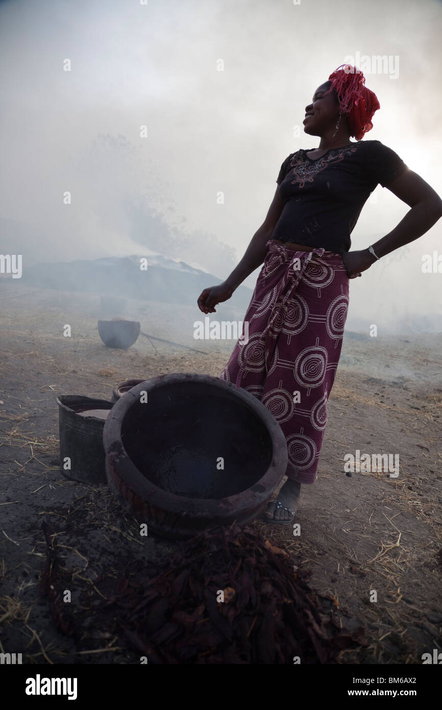 Nel villaggio di Kalabougou in Mali, accanto ai forni per ceramica, una donna che prepara lo smalto per la recente sparati in ceramica. Foto Stock