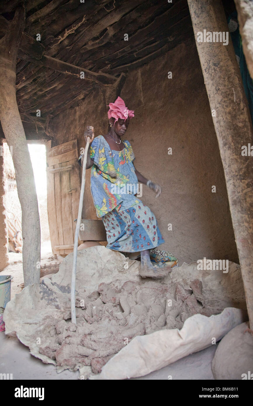 Un mix di donna piccoli pezzi di creta sparata (grog) con corpo di creta stampando su di essa nel villaggio di ceramiche di Kalabougou in Mali. Foto Stock