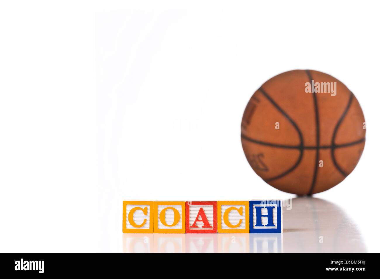 Colorata per bambini ortografia blocchi pullman con una palla da basket in background Foto Stock