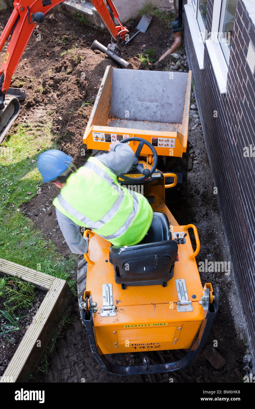 Una miniera digger e mini dumper su una casa estensione, costruzione lavoro, ambleside, cumbria, Regno Unito. Foto Stock
