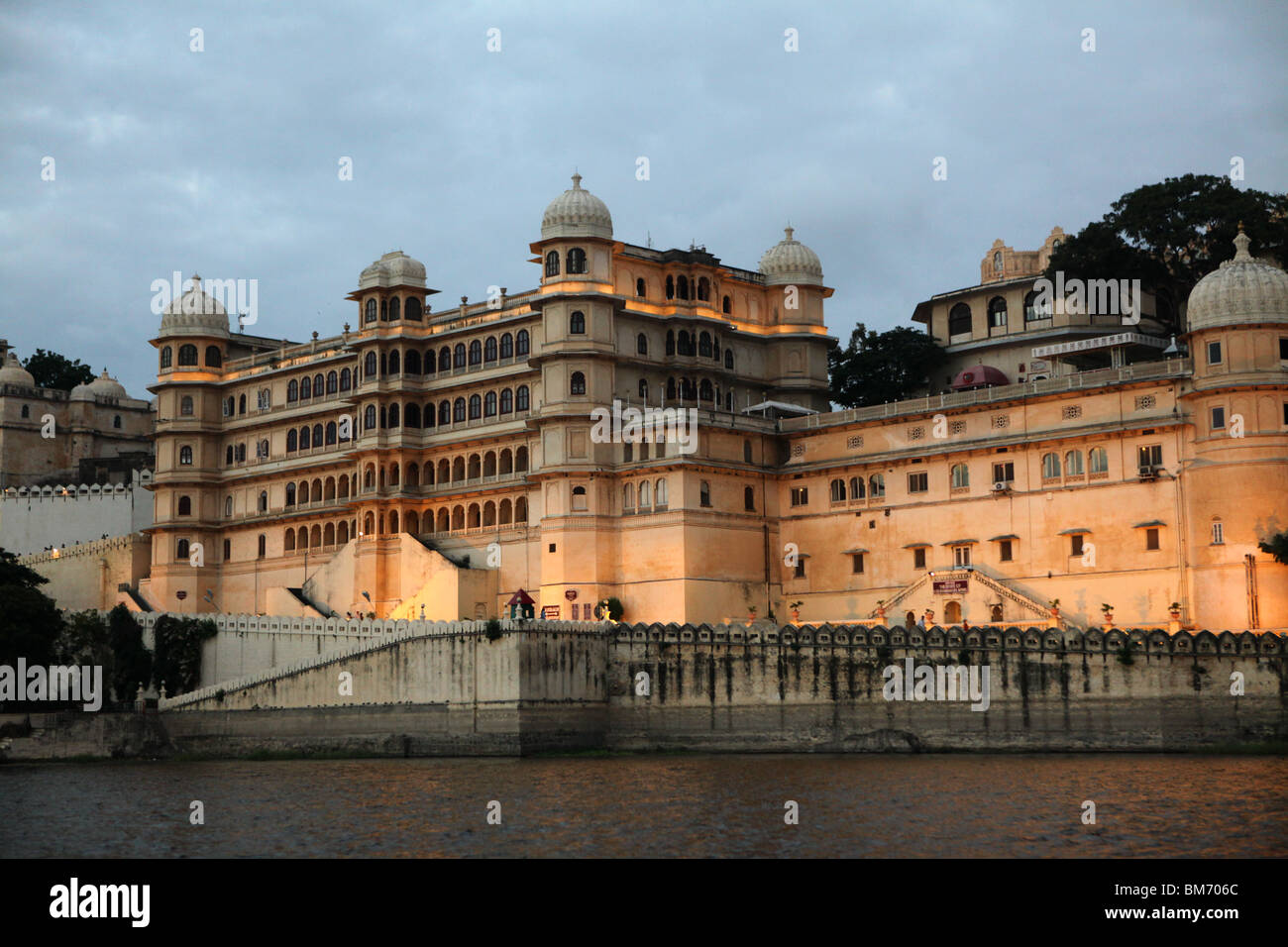 Vista sul lago Pichola verso il palazzo della città in Udaipur, Rajasthan in India. Foto Stock