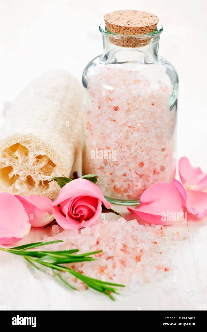 Rosa sali da bagno in un vasetto di vetro con fiori ed erbe Foto Stock