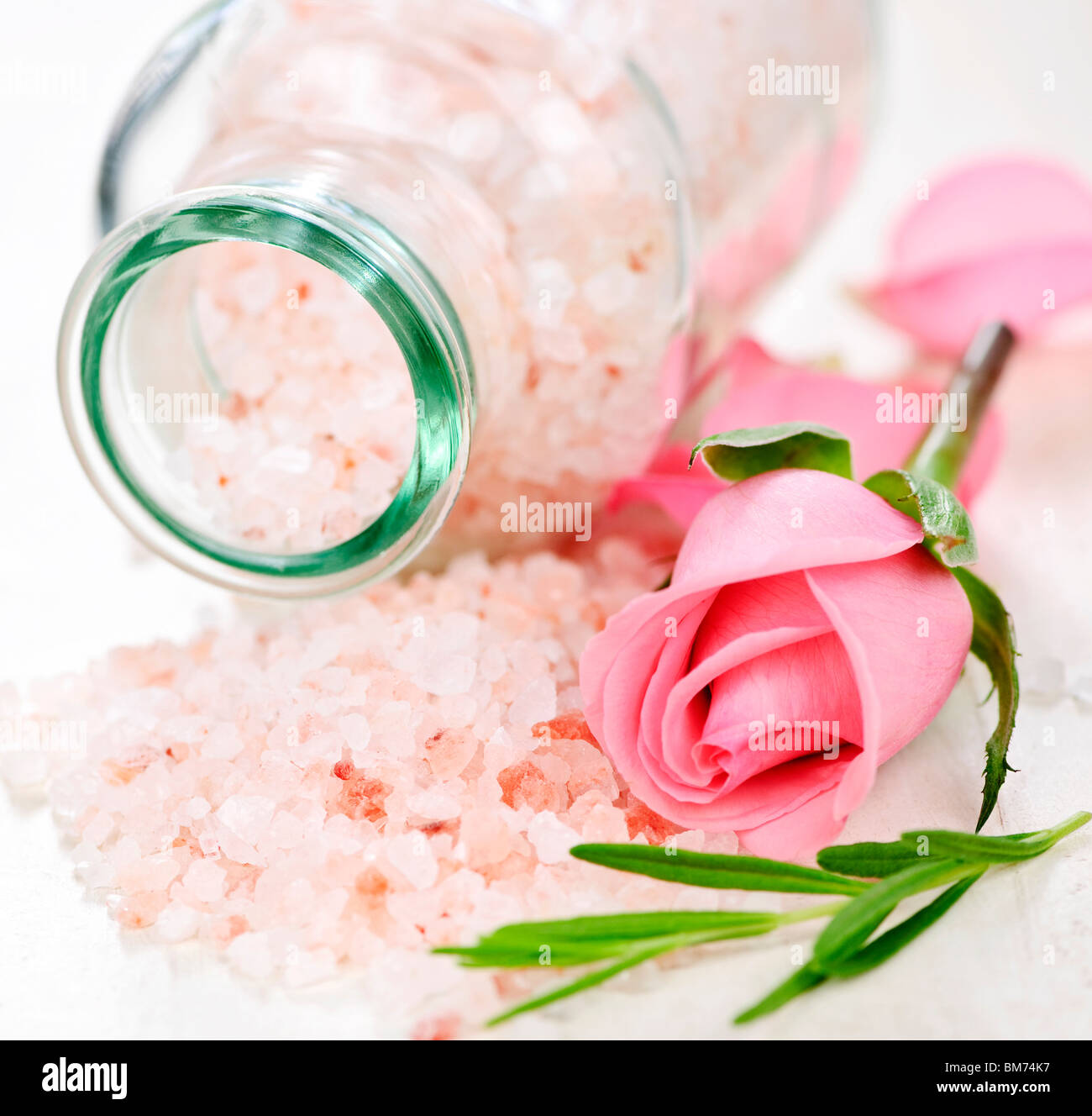 Rosa sali da bagno in un vasetto di vetro con fiori ed erbe Foto Stock