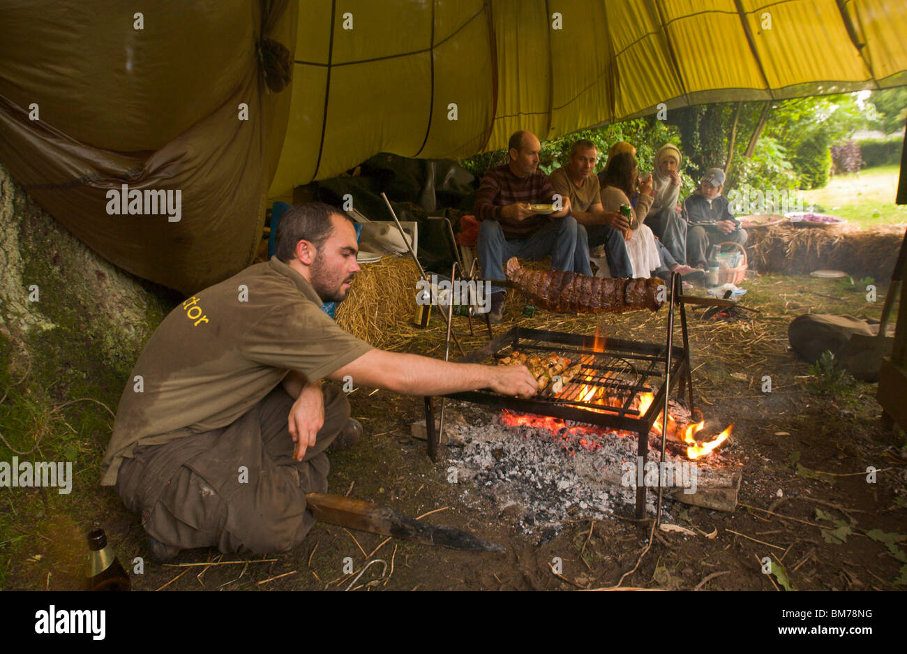 Rotolo di carne in cottura su spiedo su un fuoco aperto a barbecue su Gower Swansea South Wales UK Foto Stock