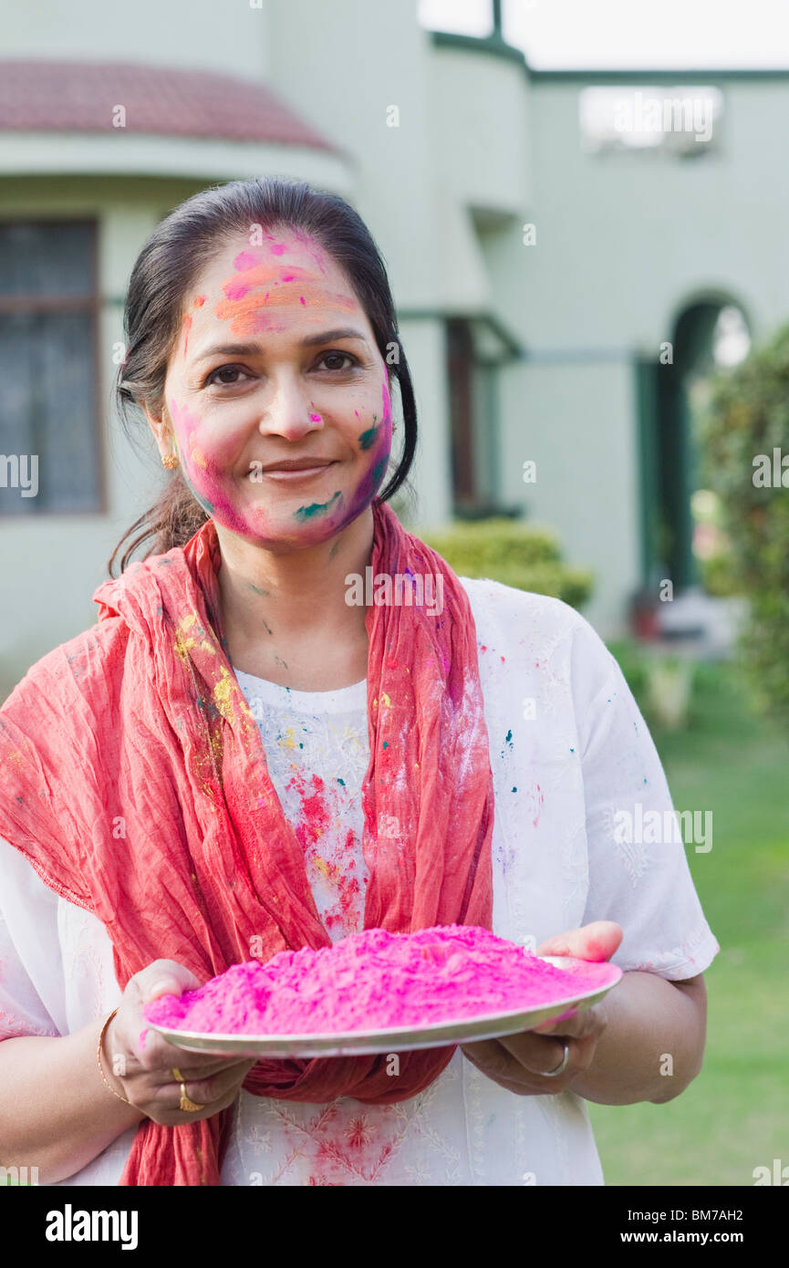 Donna che mantiene una piastra di vernice in polvere e di celebrare Holi Foto Stock
