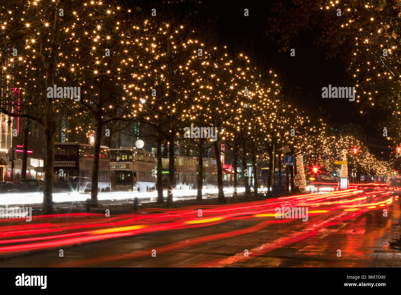 In scena con il traffico in movimento e gli alberi decorati con luci, Unter den Linden, Berlino, Germania Foto Stock