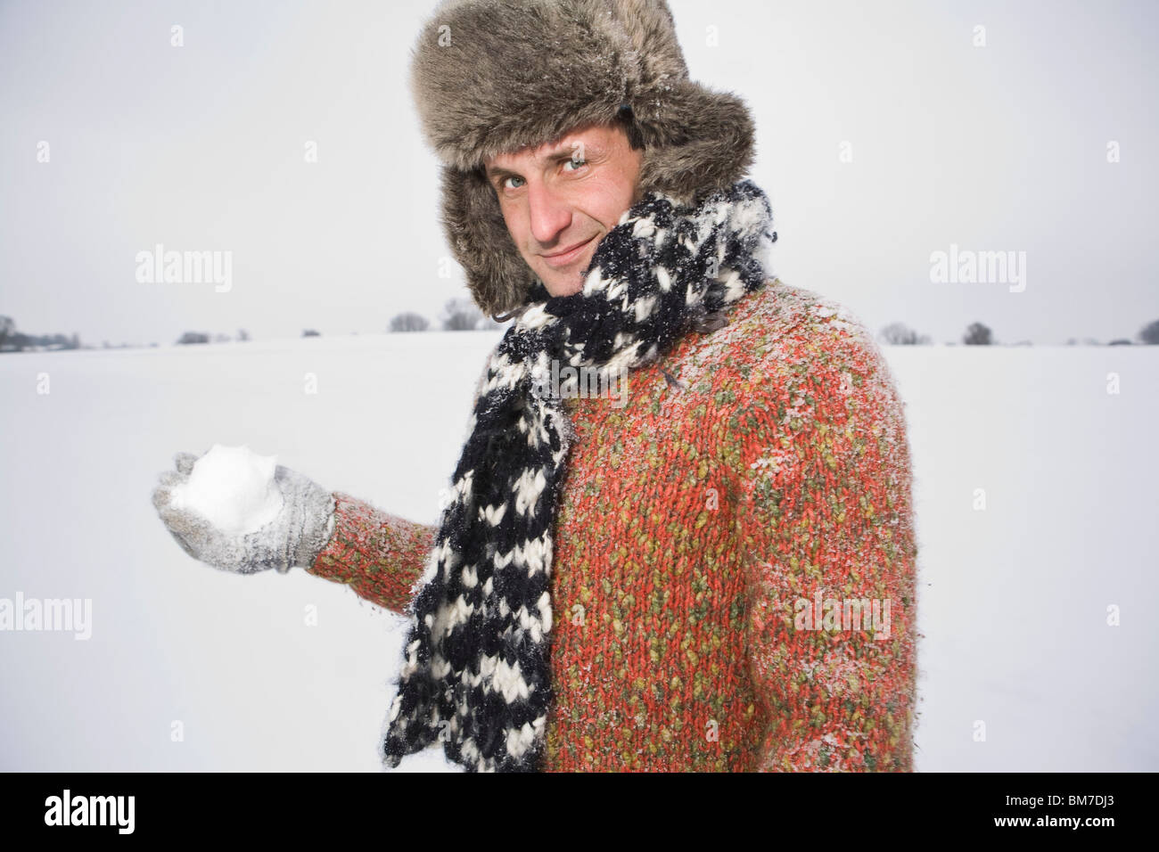 Un uomo si prepara a lanciare una palla di neve Foto Stock