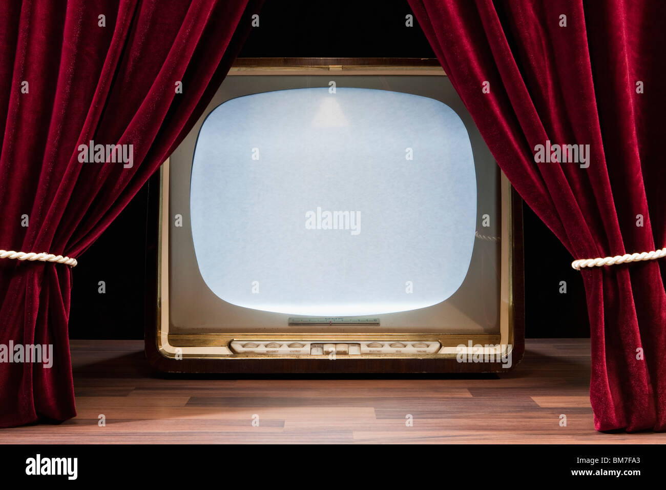 Un vecchio televisore dietro il Teatro rossi tendaggi Foto Stock