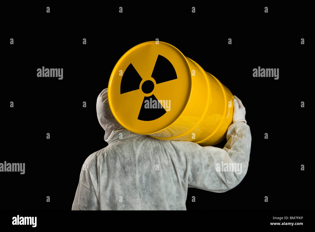 Una persona che porta un cilindro radioattivo Foto Stock