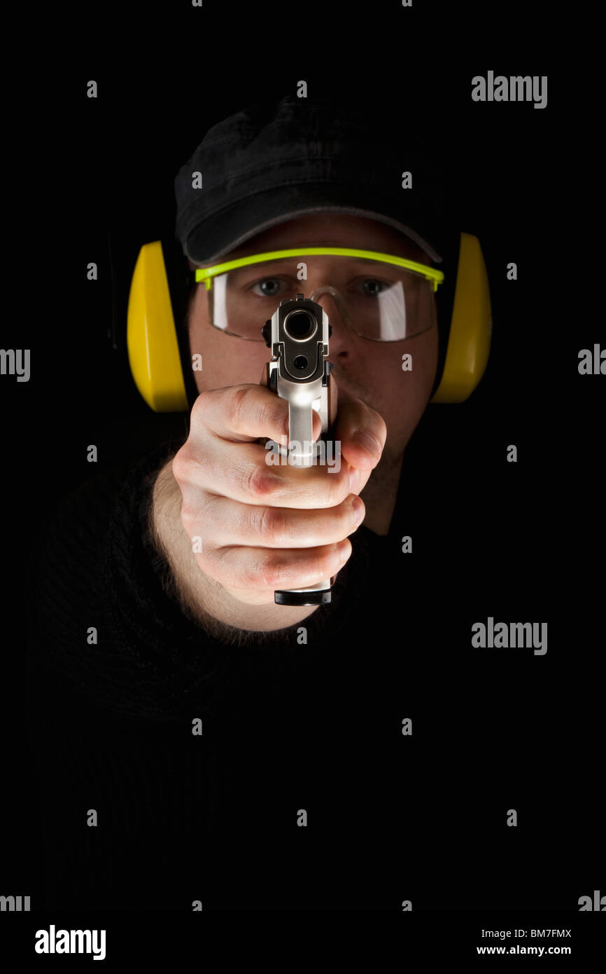 Un uomo che ha di mira una pistola Foto Stock