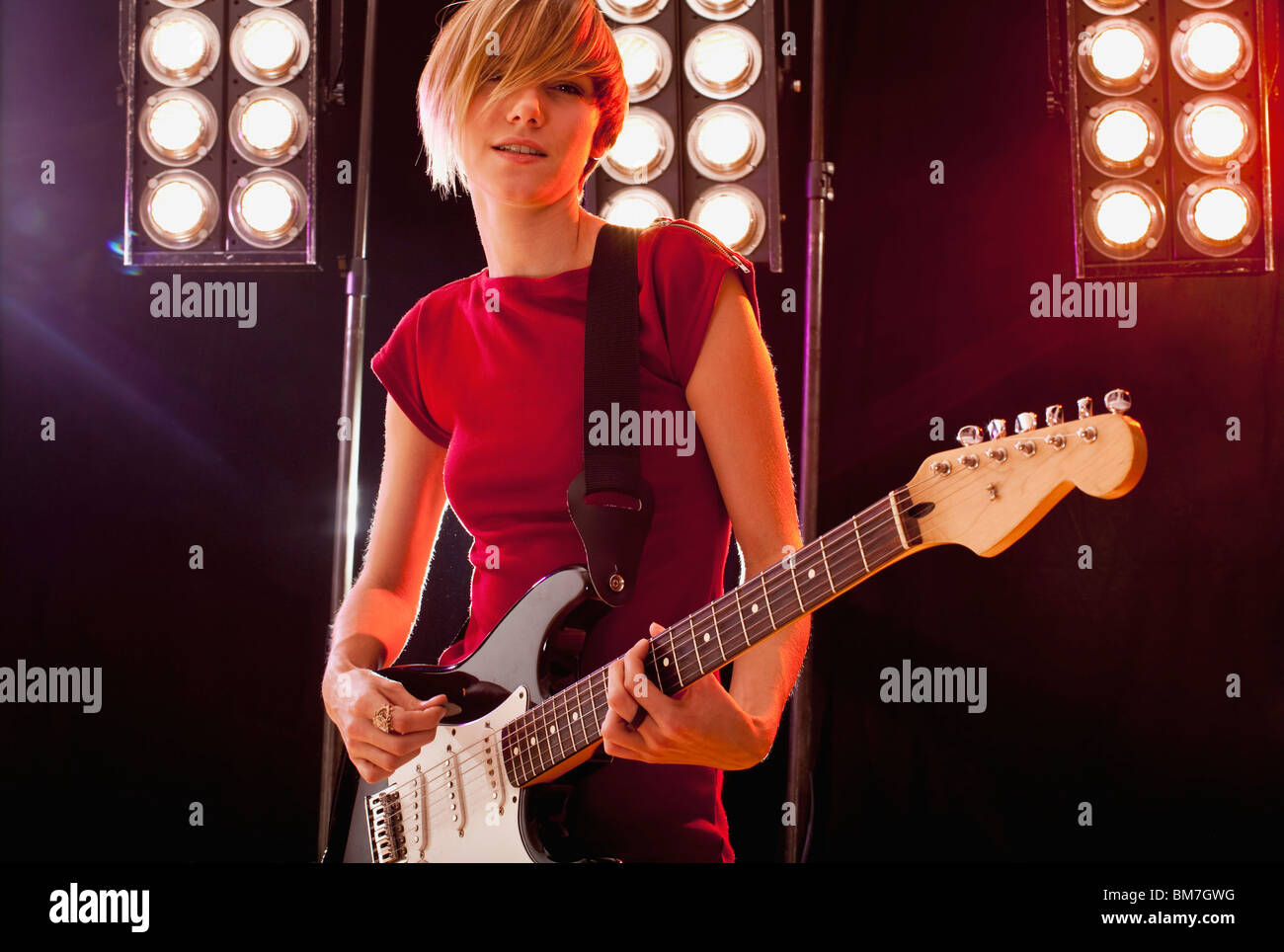 Una donna che gioca con la chitarra elettrica di eseguire sul palco Foto Stock