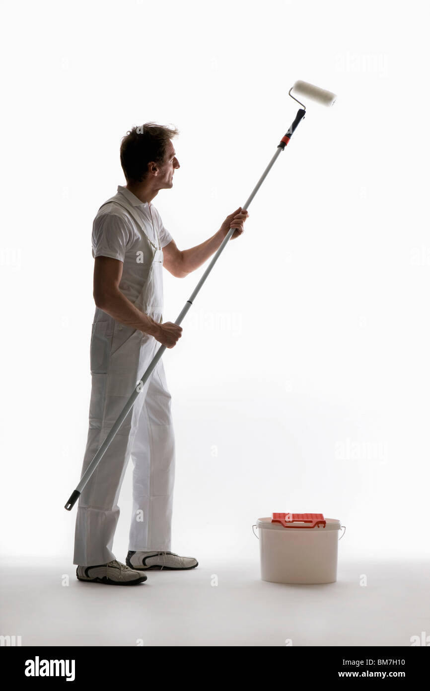 Un pittore di casa usando un rullo di vernice Foto Stock