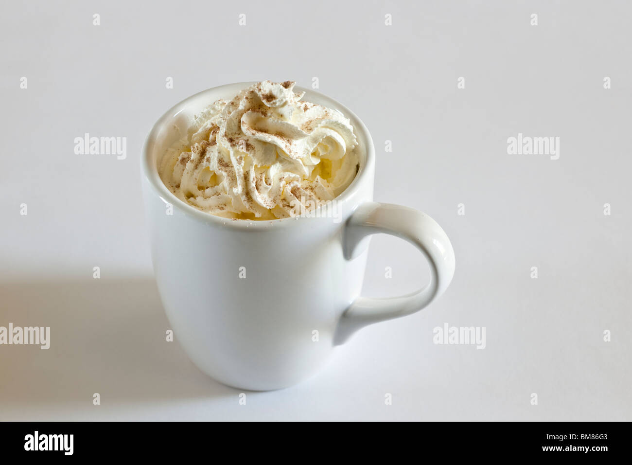 Cappuccino caffè cremoso top in un mezzo bianca mug Foto Stock