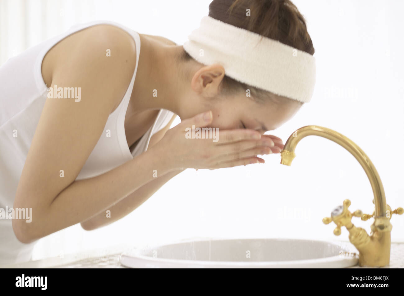 Giovane donna faccia di lavaggio Foto Stock