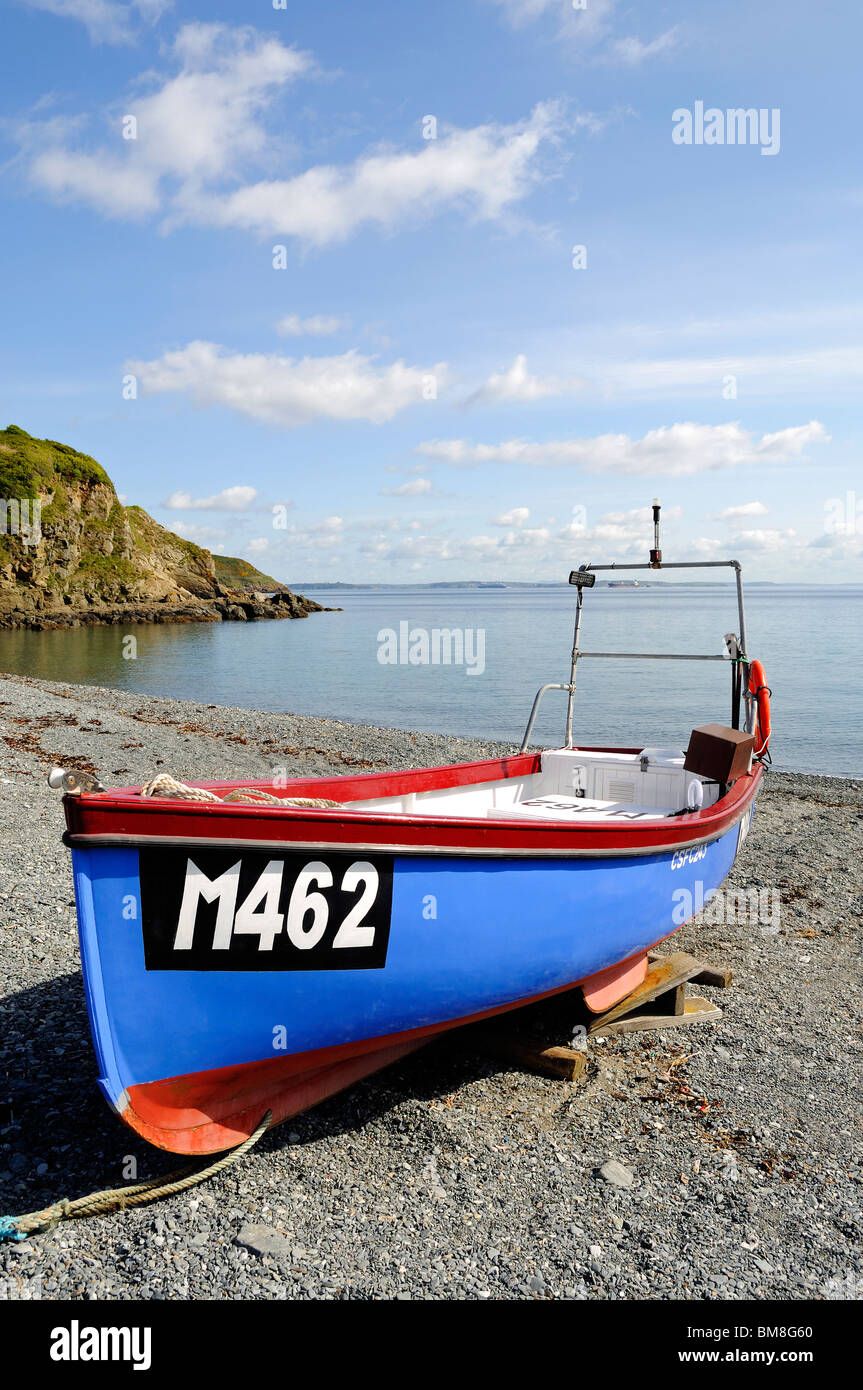 Una piccola barca da pesca ormeggiate sulla spiaggia di ciottoli a porthallow in cornwall, Regno Unito Foto Stock
