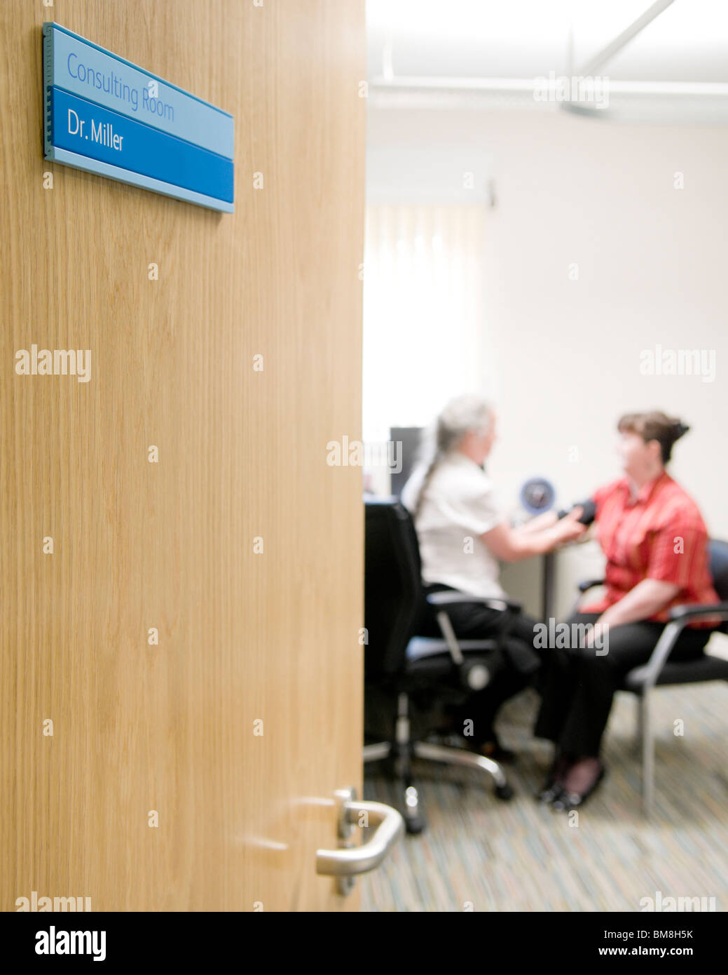 Medico tenendo i pazienti la pressione sanguigna. Foto Stock