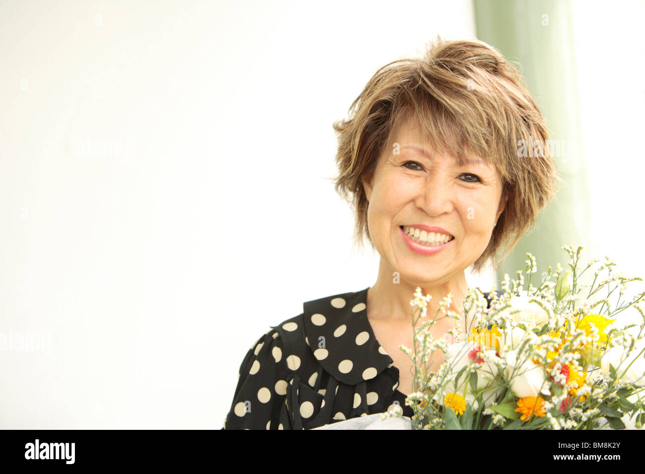 Ritratto di donna matura azienda bouquet di fiori, sorridente Foto Stock