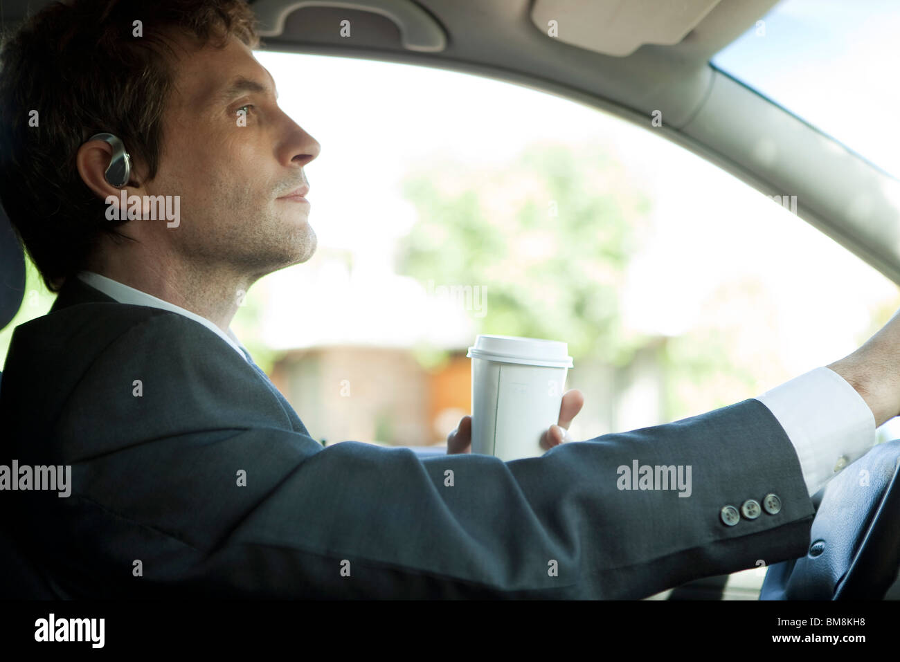 Imprenditore la guida per lavorare con la tazza di caffè in mano Foto Stock