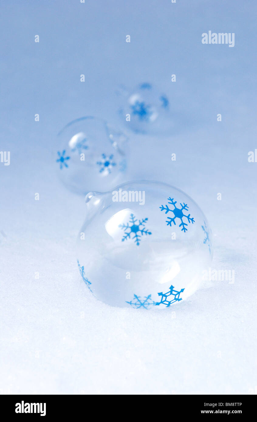 Palle di vetro con i fiocchi di neve sulla neve Foto Stock