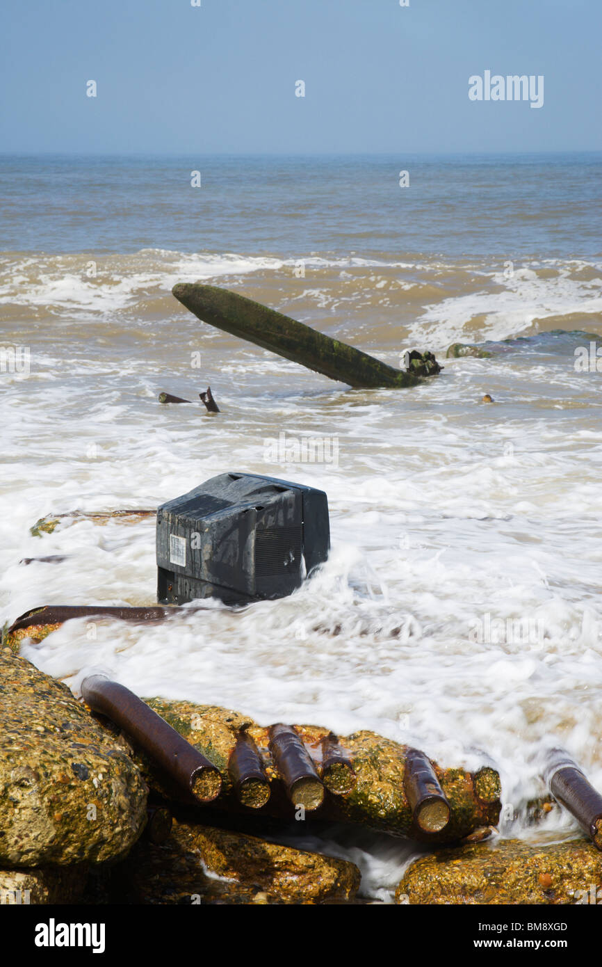 Le inondazioni del mare navigare intorno a un vecchio televisore su Happisburgh seashore, Norfolk, Inghilterra. Foto Stock